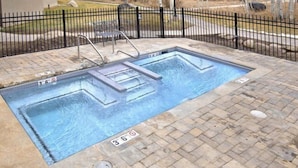 A rectangular swimming pool with a black metal fence surrounding it.