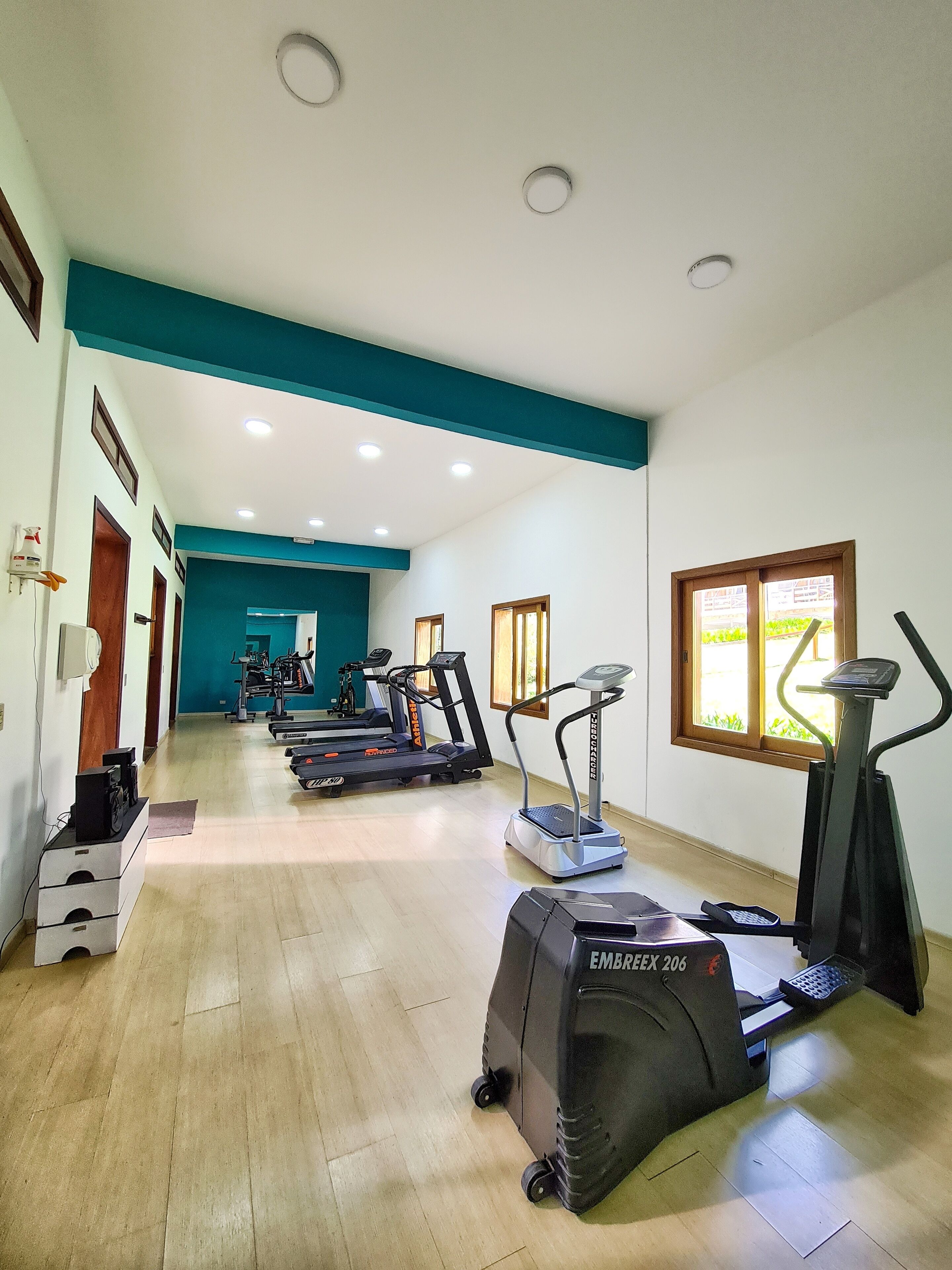 Un gimnasio con cintas de correr, elípticas y una bicicleta estática.