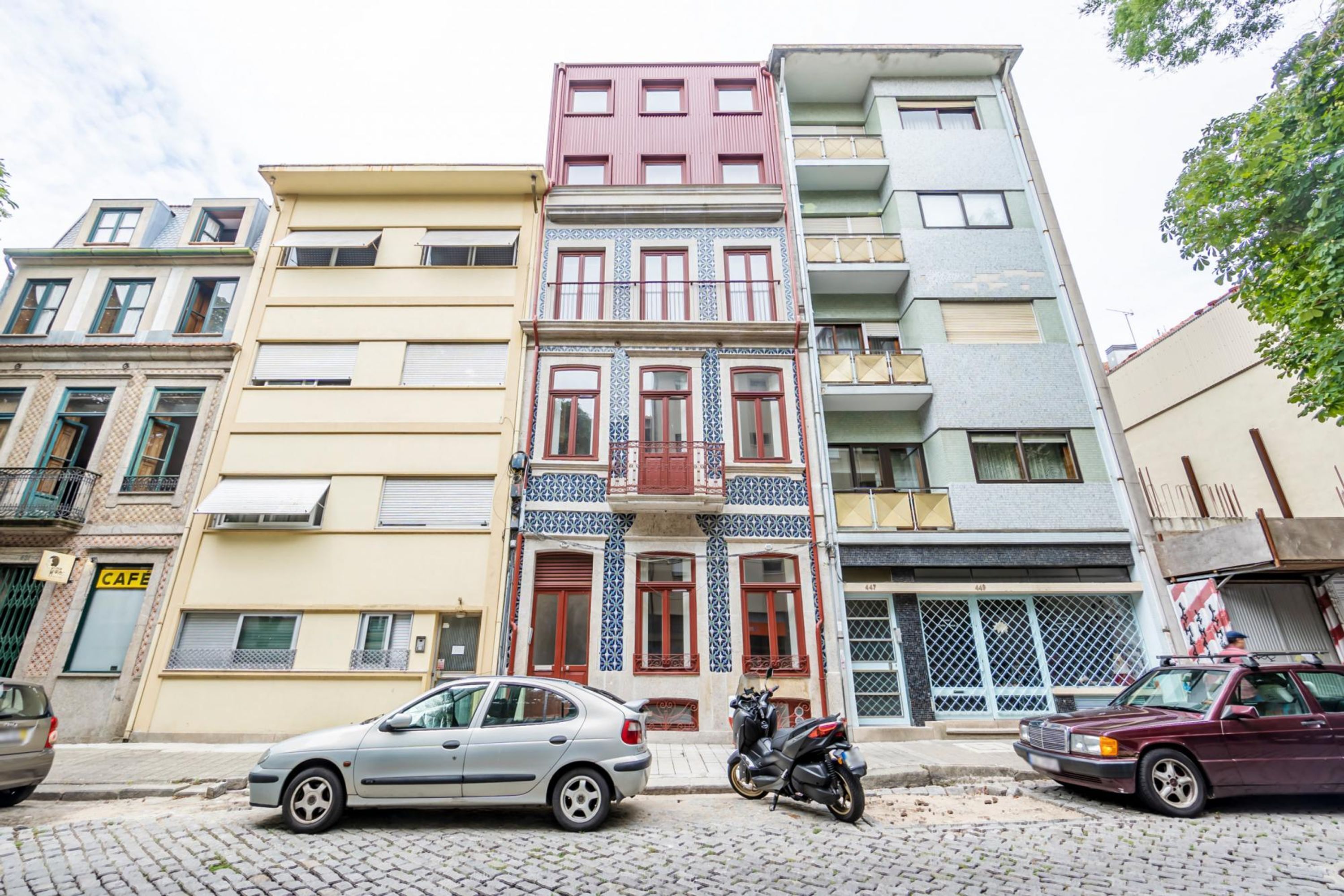 A row of multi-story buildings with a mix of architectural styles, including a building with a patterned facade and another with a plain exterior.