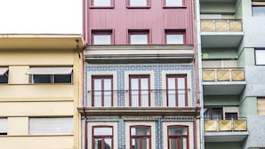 A multi-story building with distinct architectural styles, including a pink facade with large windows and a patterned blue and white section. - Nomad s Lux - 1bdr Charming Top Floor Porto (Porto)