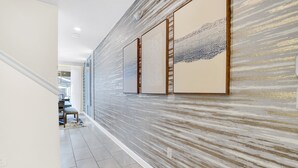 A hallway with a textured wall, a wooden floor, and a chair in the distance. - Dream Disney Storey Lake House / private pool and 2 themed rooms 
 (Kissimmee)