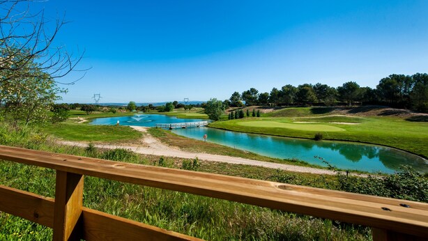 A golf course with a pond, a wooden bridge, and a clear blue sky. - La Cabre d'Or - Duplex climatisé (Cabriès)