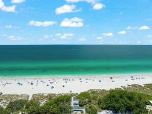 Ranta lähistöllä, aurinkotuoleja, rantapyyhkeitä