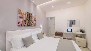Een moderne slaapkamer met een groot bed, een bureau met een computer en een spiegel.