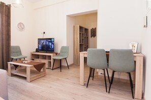 Relax in this stylish living space, featuring a flat-screen TV, comfortable seating, and a dining area.