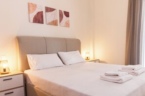Relax in a spacious room with a large bed, bedside table, and abstract art pieces.