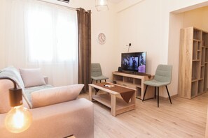 Relax in this stylish living room with a comfortable sofa, flat-screen TV, and wooden coffee table.