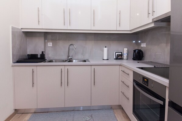 Enjoy cooking in this well-equipped kitchen with an oven, stainless steel sink, and ample countertop space.