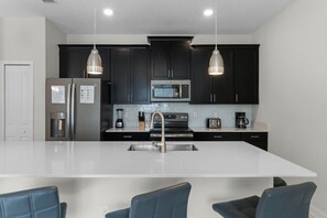 Enjoy cooking in this well-equipped kitchen with a central island, oven, and refrigerator.