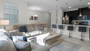 Una sala de estar moderna con sofá, mesa de centro y comedor.