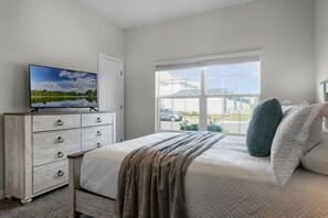 Relax in this serene bedroom with a large bed, television, and scenic view.