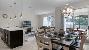 Una cocina moderna con comedor, ventanas amplias y vista a zonas verdes.
