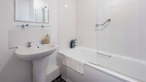 A bathroom with a white sink, a mirror, and a glass-enclosed shower. - Central 1 BR apartment in Birmingham (Birmingham)