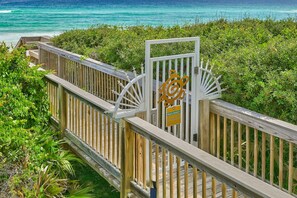 A wooden boardwalk leading to a gated entrance with a sign indicating private property and no trespassing.