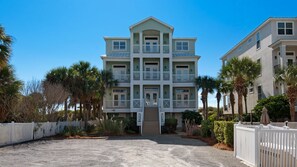 A multi-story building with a symmetrical facade, balconies, and a gated entrance.