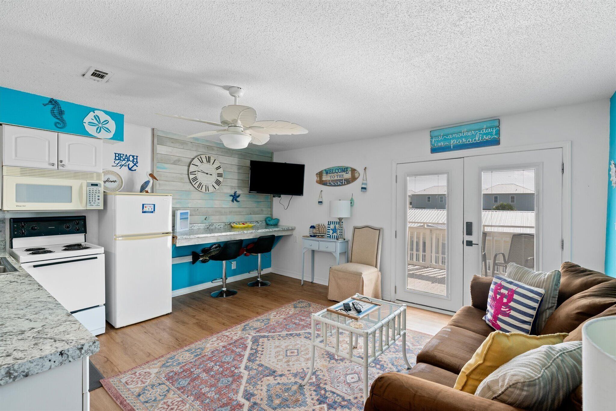 A compact living space with a kitchenette, a dining area, and a seating area with a couch and coffee table.