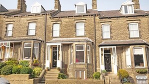 A row of terraced houses with front doors, windows, and steps leading to the entrance. - Brylie House, Large Central Family Home (Skipton)
