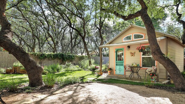 A small house with a porch, surrounded by trees and a garden. - Romantic~Butterfly Cttg~Central Loc, Firepit ~Oaks (San Antonio)