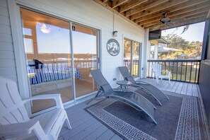 Eine überdachte Terrasse mit Sitzgelegenheiten, eine Schiebetür und ein Logo an der Wand.