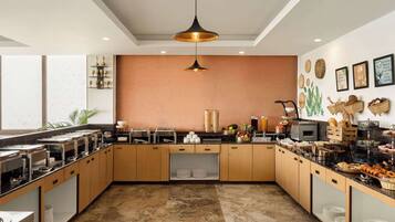 A modern kitchen with wooden cabinets, a marble floor, and various breakfast items on the counter.