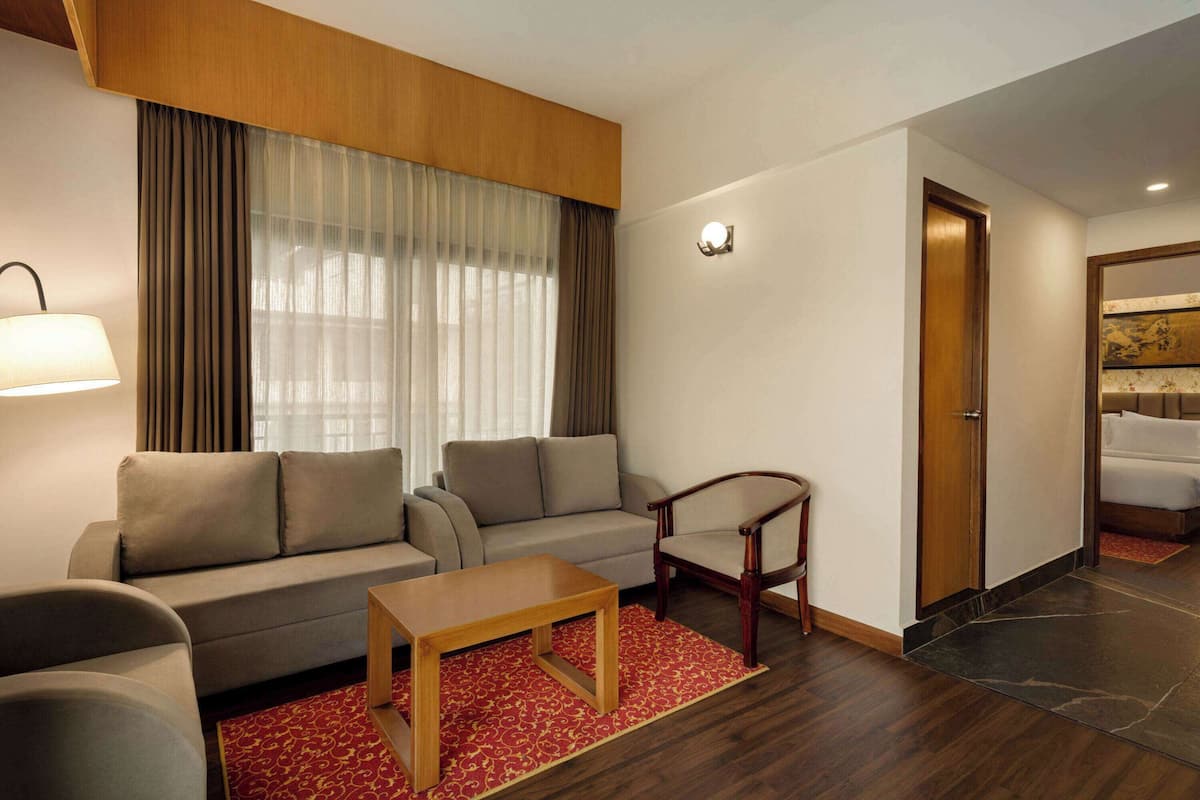 Une chambre d’hôtel moderne avec un canapé, un fauteuil et une petite table.