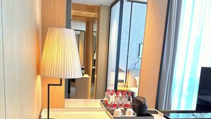 Une chambre d’hôtel équipée d’un bureau, d’un miroir, d’une lampe, d’une machine à café et d’un téléviseur.
