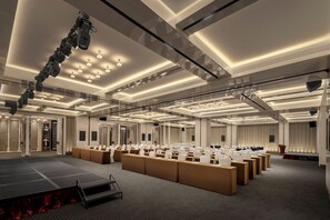 A spacious conference room with a stage, multiple rows of tables, and a modern ceiling design. - Howard Johnson By Wyndham Wenting Hotel Changsha (Changsha)