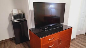 A compact living space with a flat-screen TV on a wooden cabinet, a mini-fridge, and a microwave. - Super 8 By Wyndham El Centro North (El Centro)
