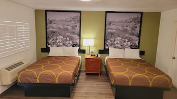 A hotel room with two beds, a nightstand, a lamp, and a large window with blinds.