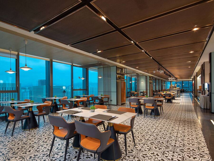 Un comedor moderno con techos altos, ventanas amplias y un piso con diseño.
