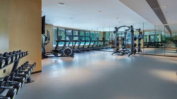 Une salle de sport moderne équipée de tapis de course, d’haltères et d’appareils de musculation.
