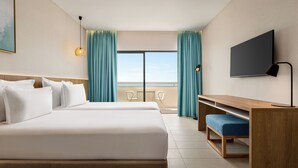 A hotel room with a large bed, a desk, a TV, and a balcony with curtains. - Wyndham Residences Alvor Beach (Portimão)