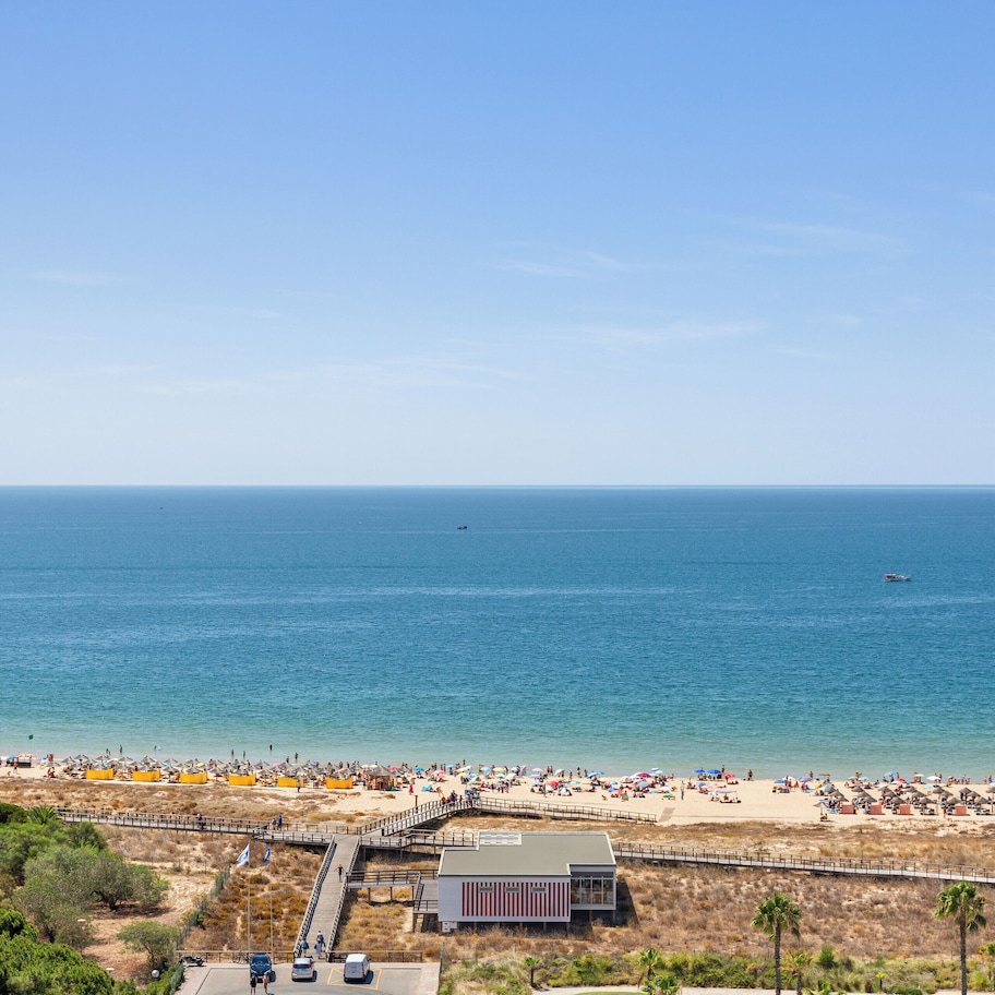 A beach with a pier and a building in the foreground.