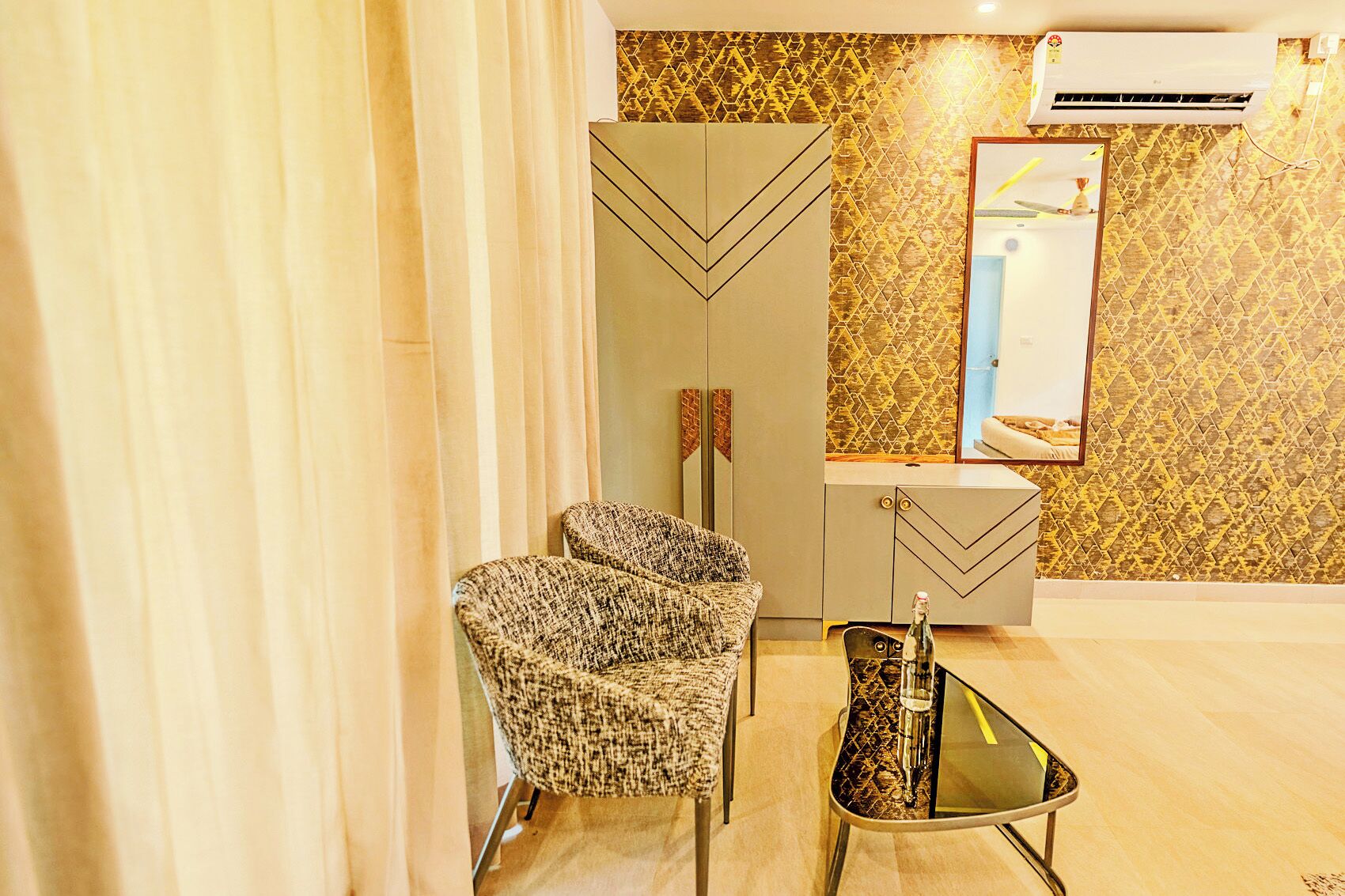 Una habitación moderna con un sofá, una mesa de vidrio y una pared decorada.