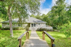 A house with a wooden deck leading to a front door, surrounded by lush greenery and trees. - Hawthorne Vacation Rental w/ Access to Cue Lake (Hawthorne)