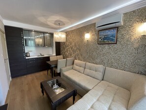 Relax in this stylish living room with a sofa, coffee table, and dining area.
