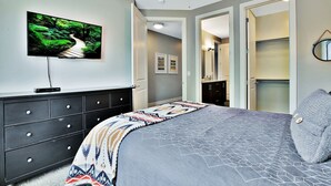 A bedroom with a bed, a dresser, a TV on the wall, and a closet. - Entrada at Moab 420 and 424 (Moab)