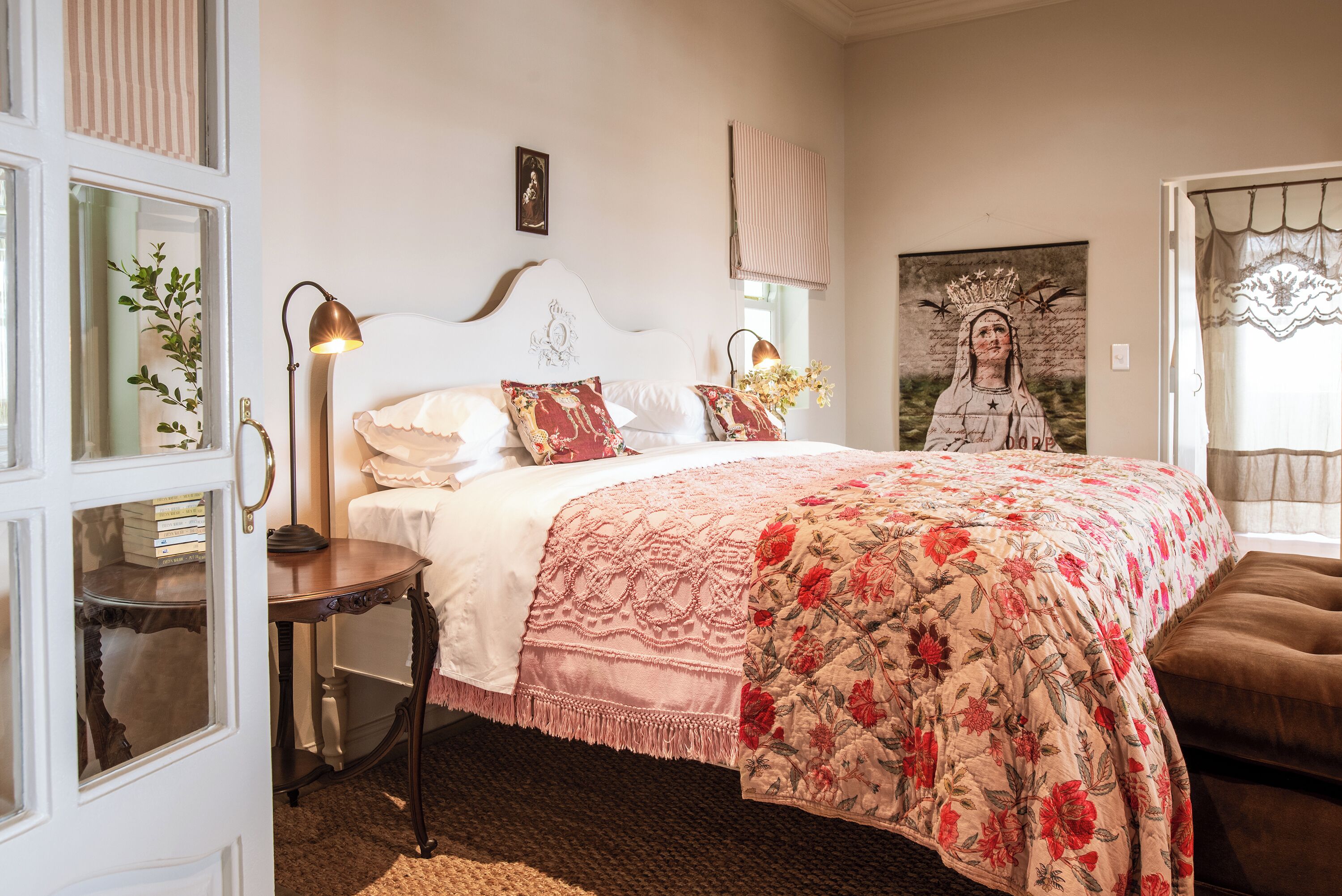 Un dormitorio con cama, mesita de noche y una colcha grande con estampado floral.