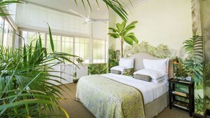 A bedroom with a large bed, a ceiling fan, and several potted plants. - Dorp Hotel (Cape Town)