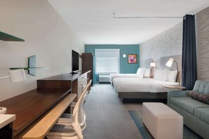Relax in comfort with a large bed, sofa, and desk, offering a peaceful retreat with a view.