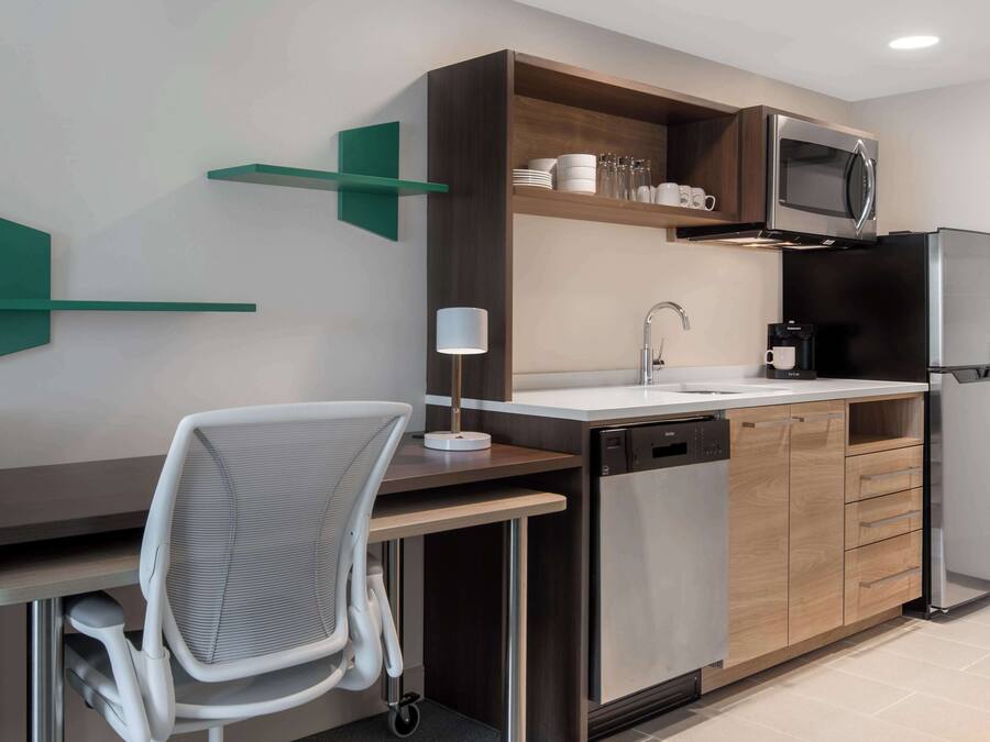 Una cucina moderna con forno a microonde integrato, macchina da caffè e lavastoviglie.