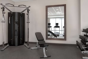 Stay fit on the go with a fully equipped gym featuring a weightlifting station, squat rack, and bench.