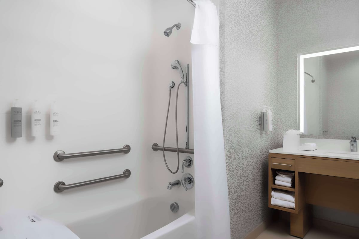 Un baño moderno con bañera, ducha y tocador.