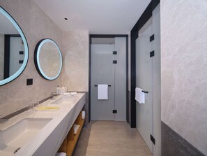 A modern bathroom with two sinks, a mirror, and a towel rack. - Hilton Garden Inn Xiamen Tong'An (Xiamen)