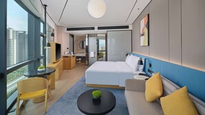 Een moderne hotelkamer met een groot bed, een bank, een bureau en een badkamer.