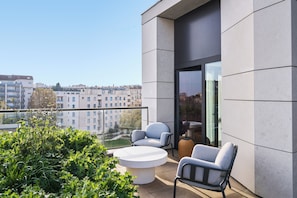 A balcony with two chairs, a round table, and a view of buildings. - TRIBE Lyon Croix Rousse (Caluire-et-Cuire)