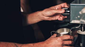 A person holding a cup of coffee from a machine.