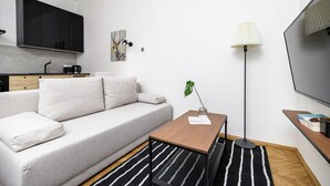 Ett modernt vardagsrum med en soffa, ett soffbord och en tv som är monterad på väggen.