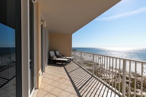A balcony with two sun loungers and a view of the beach.