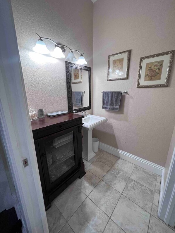 A bathroom with a vanity, sink, and two framed pictures on the wall. - Lake-Themed Private Guest Suite Gated Community Pet Friendly Near I-4 (Plant City)